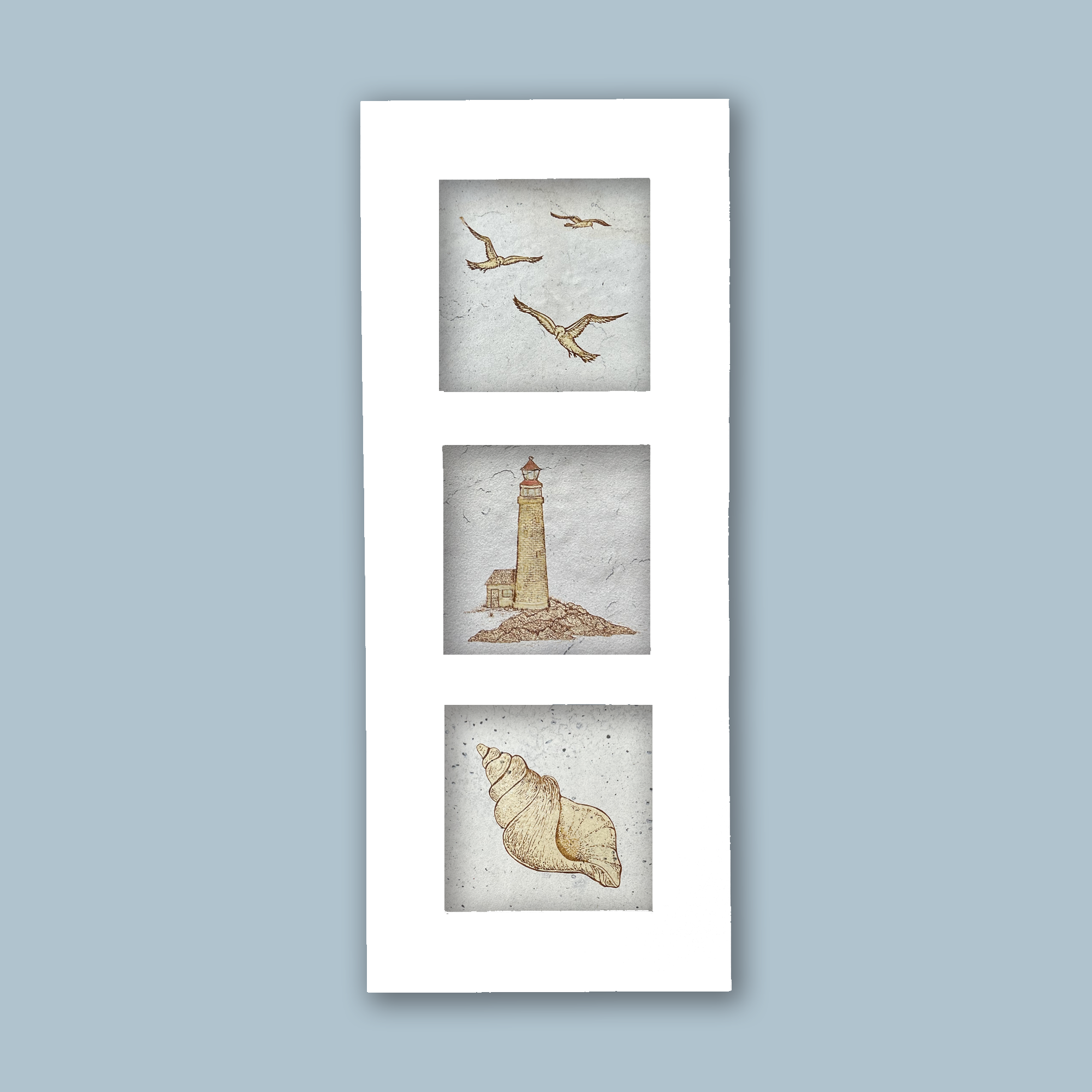 A lighthouse, sea shell and seagulls on beige porcelain tile displayed in a white aluminum frame