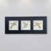A trio of three different delicately coloured hummingbirds on beige porcelain tile mounted  horizontallyin a black anodized aluminum frame