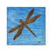 A laser engraved dragonfly on a blue stain baltic birch art tile 