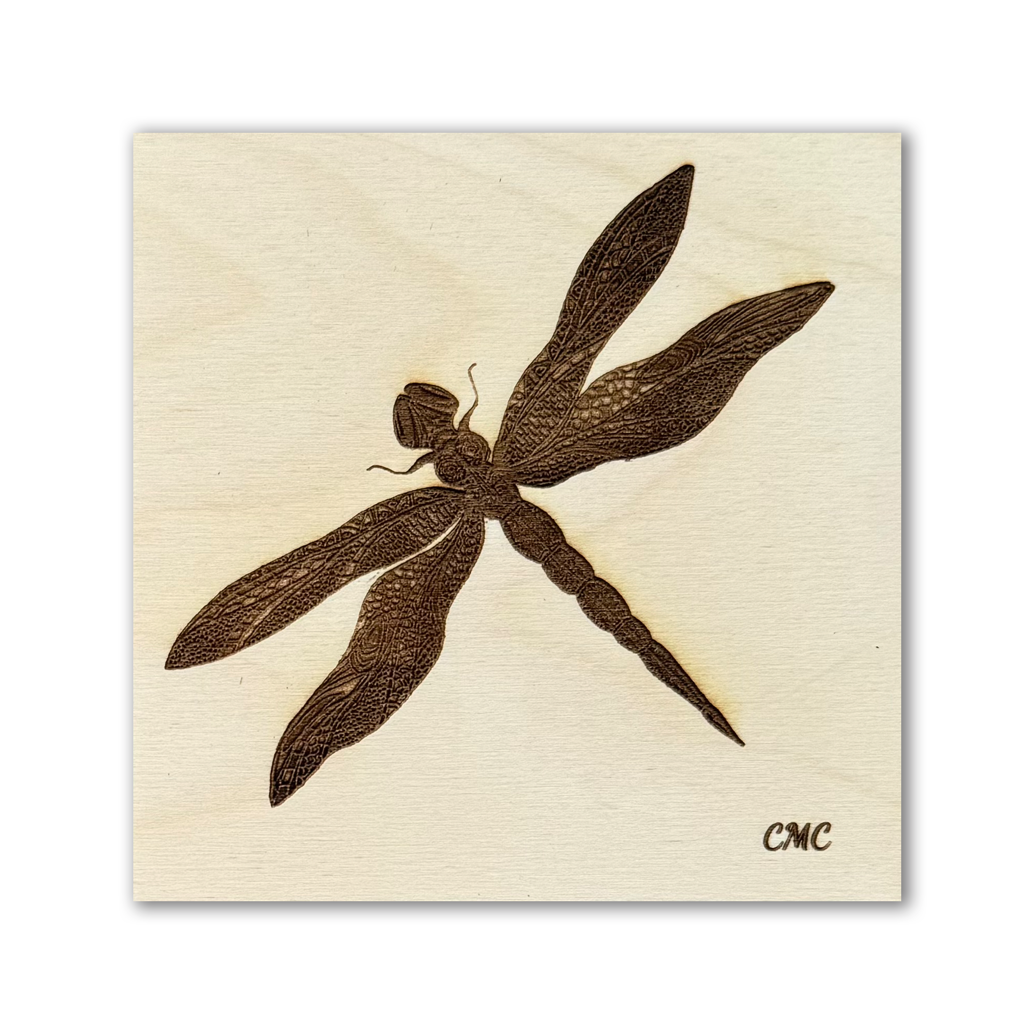 A laser engraved dragonfly on a natural baltic birch art tile 