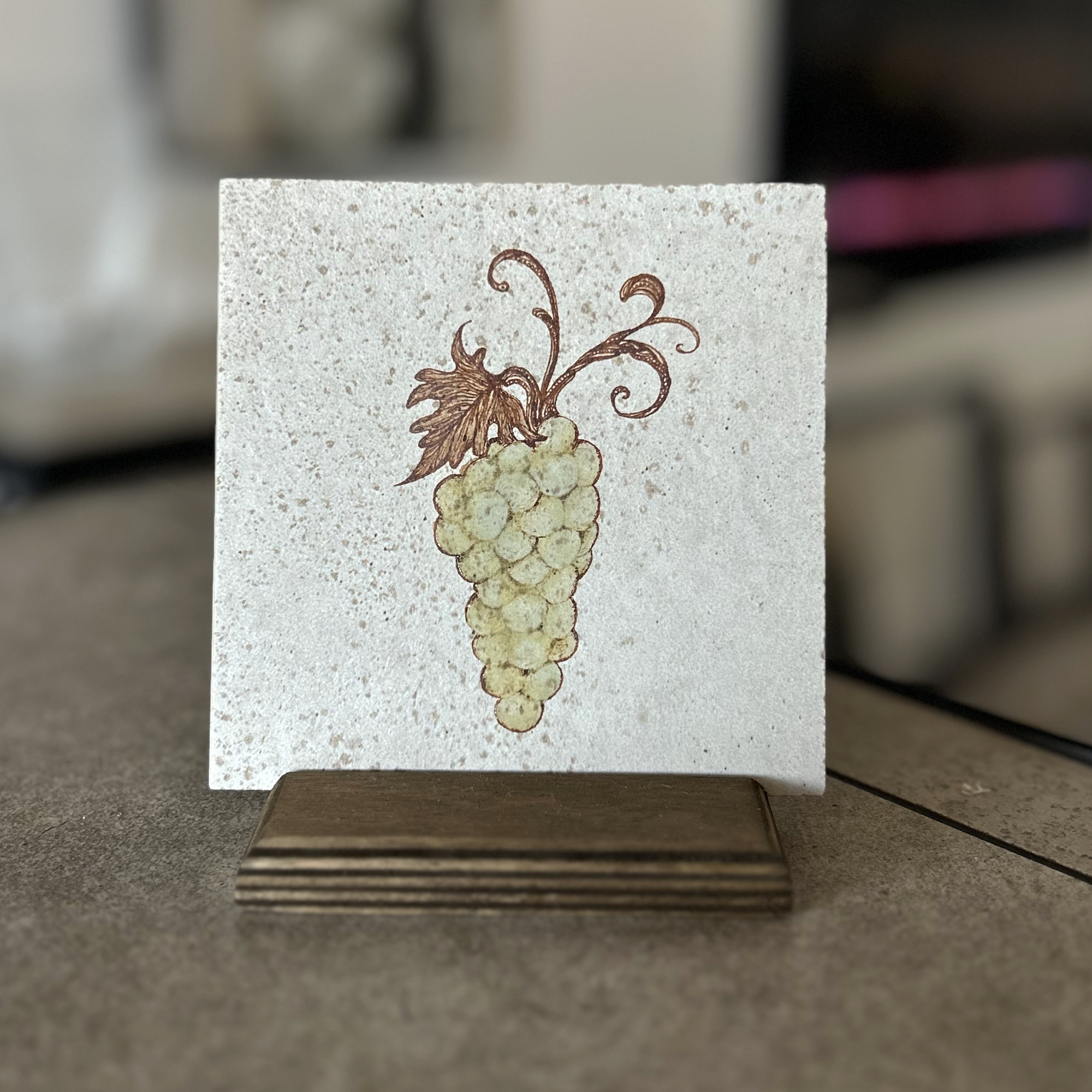 Original design glazed green grapes on beige variegated porcelain tile displayed on a earth stain baltic birch stand
