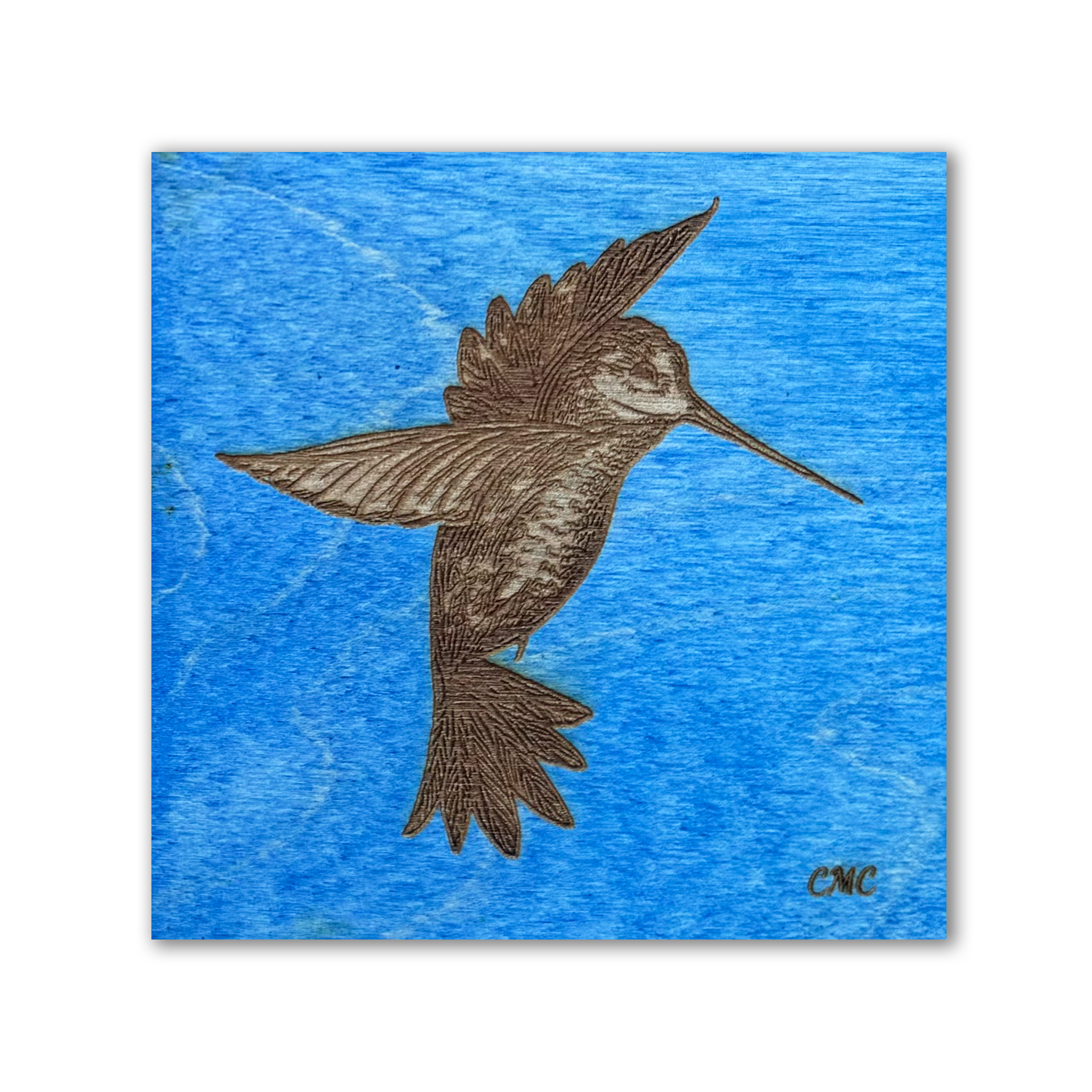 Laser engraved hovering humminbird on blue stain baltic birch tile 