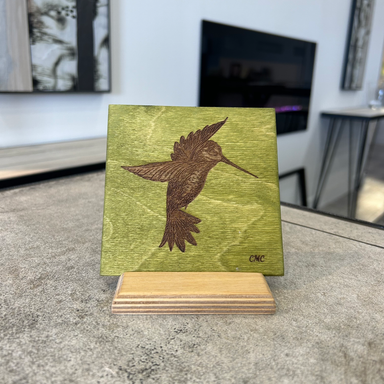 Laser engraved hovering humminbird on green stain baltic birch tile with a baltic birch stand in natural